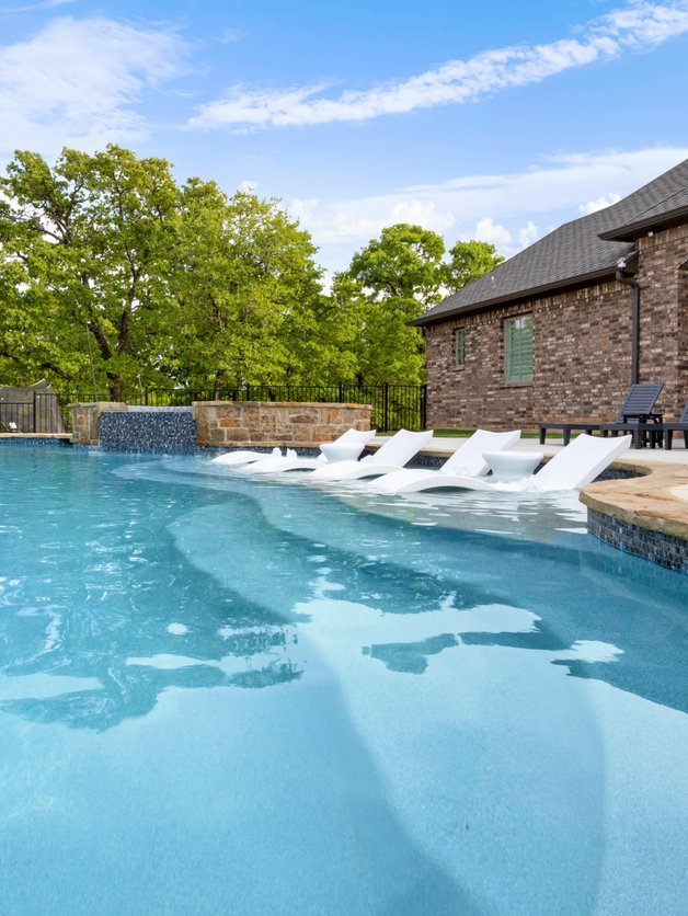 Row of in-water loungers along pool tanning ledge