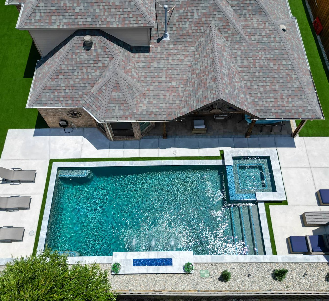 Aerial rectangular pool with attached spa and loungers