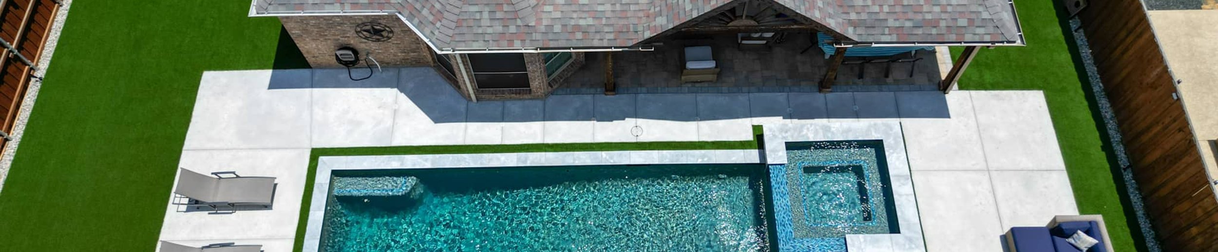Aerial rectangular pool with attached spa and loungers