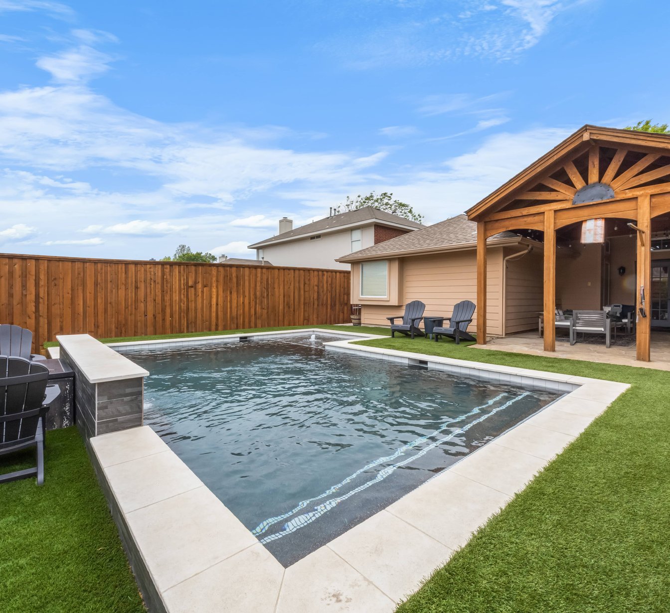 Dark-bottom pool with pergola and Adirondack chairs