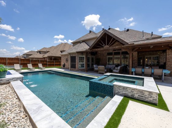 Rectangular pool with spa and gabled outdoor pavilion
