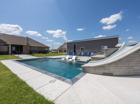 Pool with stone water slide and tanning shelf