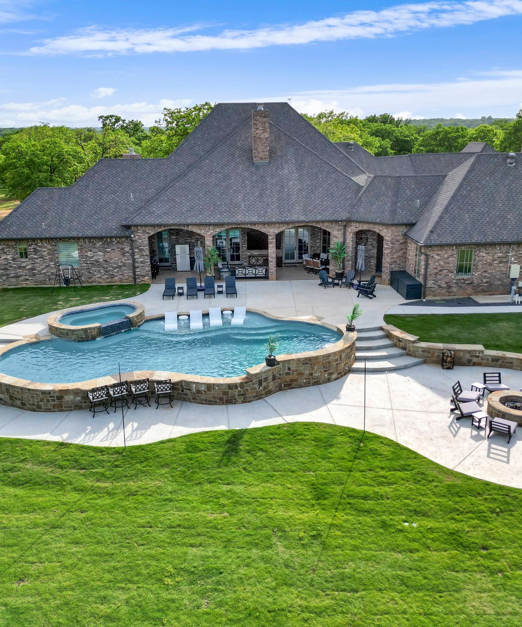 Complete outdoor living space with pool, pergola and kitchen by TidalWave Custom Pools