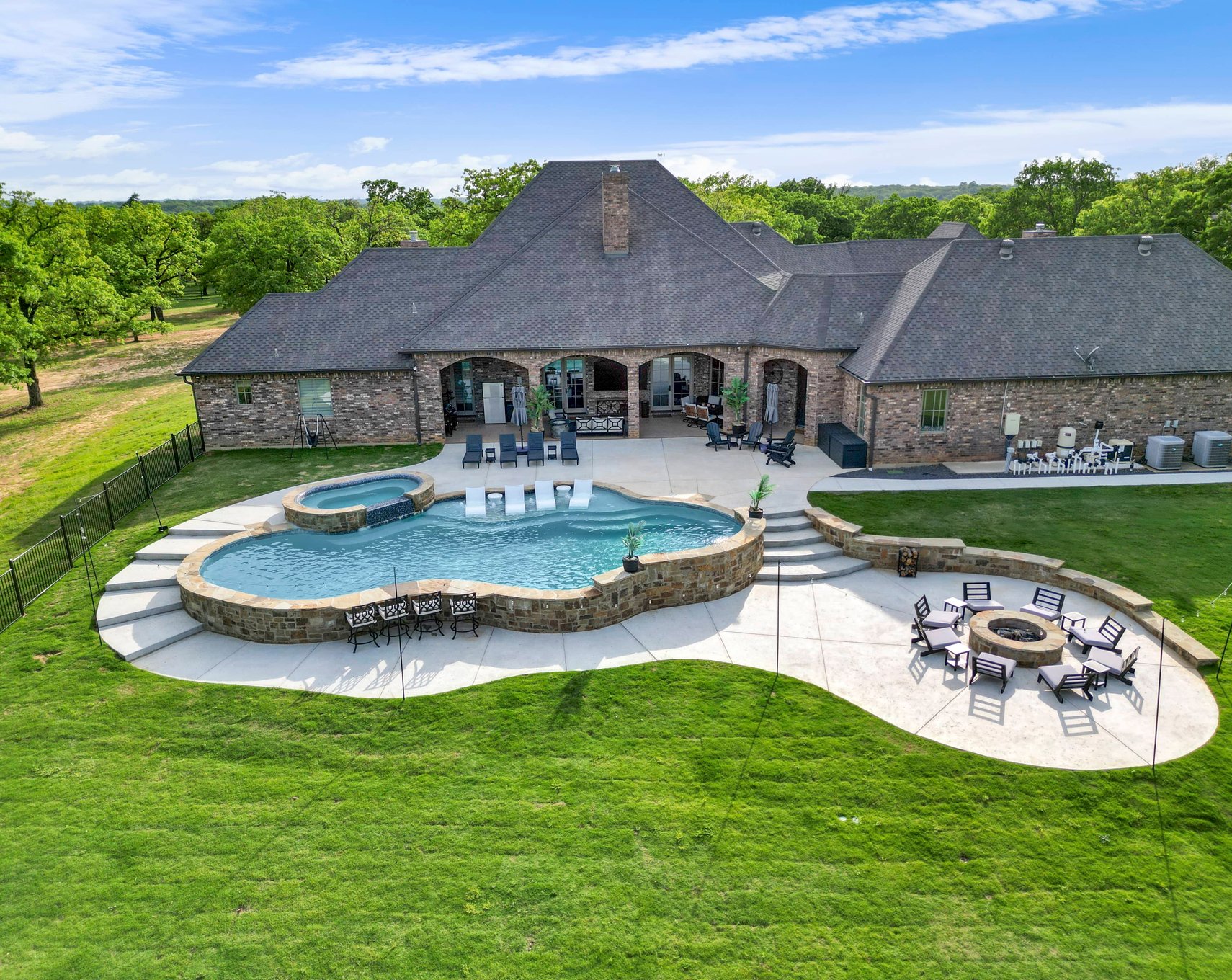 Freeform pool aerial view with fire pit patio
