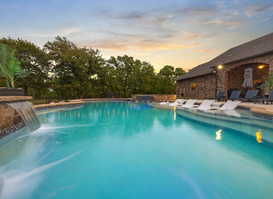 Freeform pool with waterfall at sunset