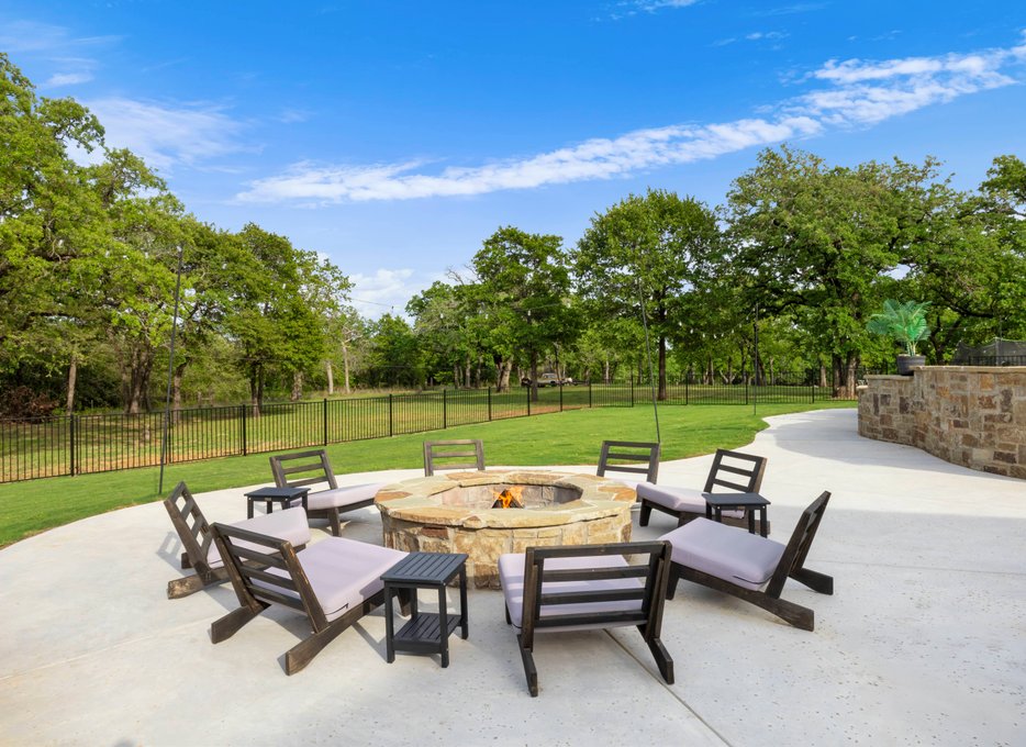 Stone fire pit with seating on concrete patio
